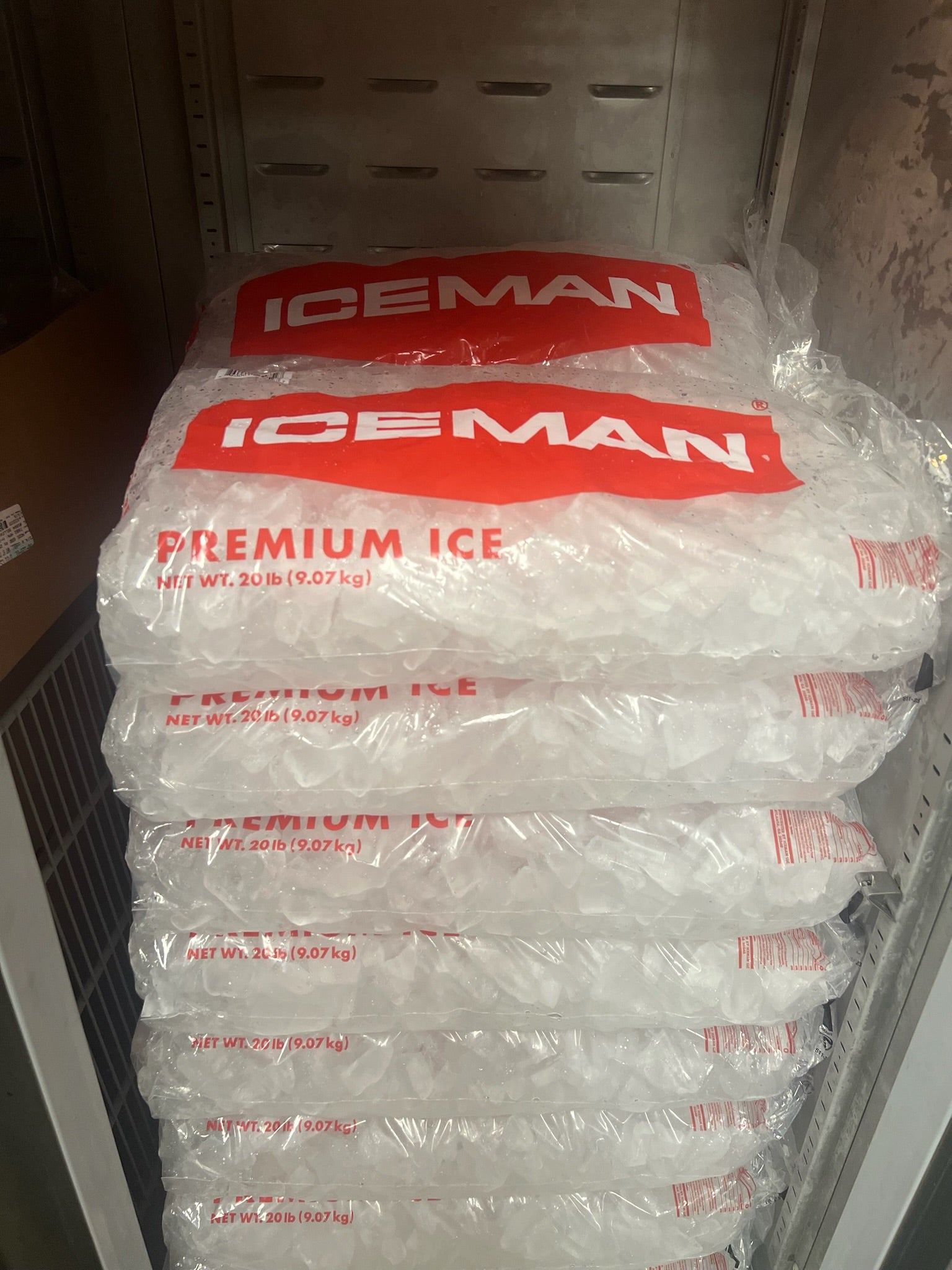 Stacks of 20 lb Iceman packaged ice in a walk-in freezer, ready for emergency ice delivery to bars, restaurants, and events in Jacksonville, FL-Iceman LLC